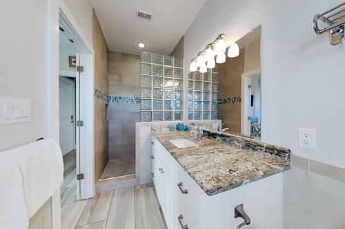 a white bathroom with a sink and a shower at Beautiful Sea in Port Aransas