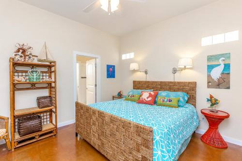 a bedroom with a bed with a blue comforter at Jamaica Me Happy at Pirate's Bay Unit 303 in Port Aransas