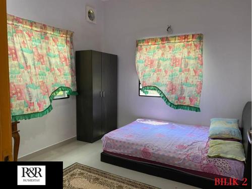 a bedroom with a bed and two windows with curtains at R & R HOMESTAY in Tanjung Karang