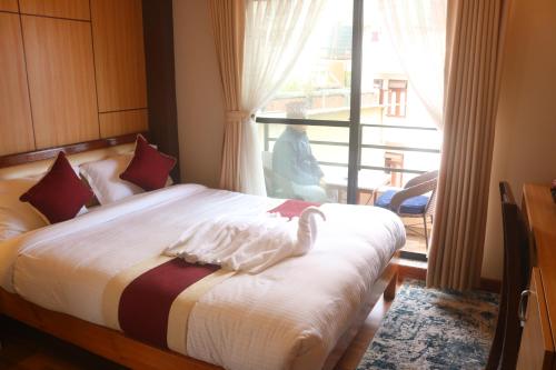 a bedroom with a bed and a large window at Hotel Family Ties Pvt. Ltd. in Kathmandu