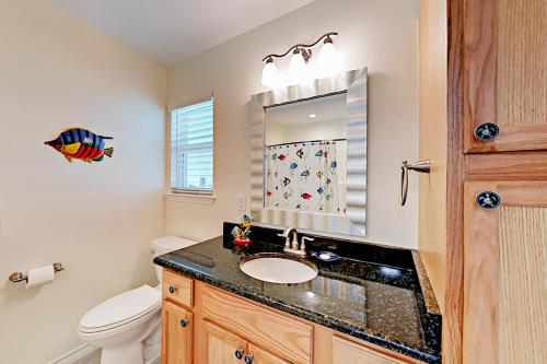 a bathroom with a sink and a toilet and a mirror at South Pearl Sailfish in Rockport