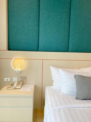 a bedroom with a bed and a phone on a night stand at The Poem Hotel in Mae Pim