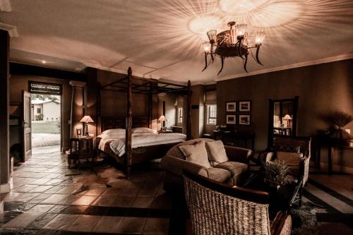 a bedroom with a bed and a chandelier at Dawsons Game Lodge in Badplaas