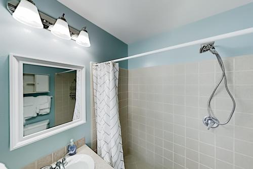 a bathroom with a shower and a sink and a mirror at Island Escape & Huisache Townhome in South Padre Island