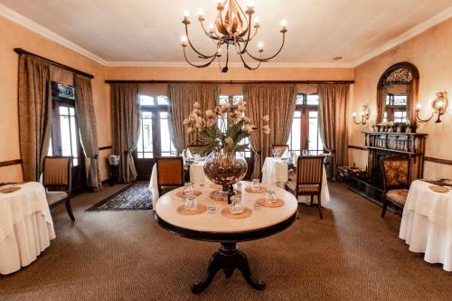 una sala da pranzo con un tavolo e un lampadario di Dawsons Game Lodge a Badplaas