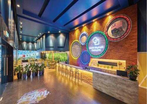 a restaurant with a bar with tables and chairs at Hotel Olympic Malaysia Kuala Lumpur in Kuala Lumpur