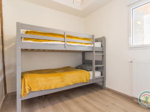 een slaapkamer met een stapelbed met gele lakens bij Gîte Casson, 3 pièces, 4 personnes - FR-1-306-854 in Casson