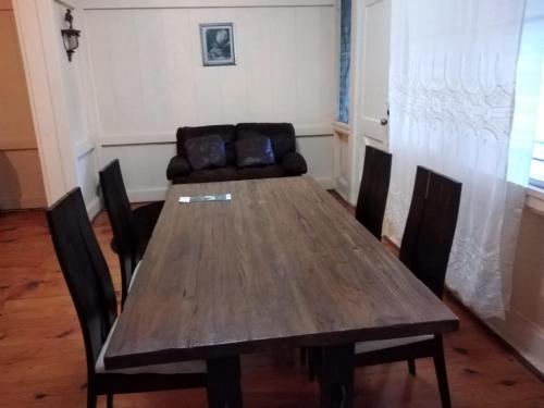 uma mesa de madeira com cadeiras e um sofá num quarto em Casa Gamboa Remodelada em Gamboa