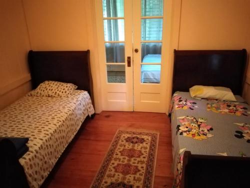 two beds sitting in a room with a door at Casa Gamboa Remodelada in Gamboa