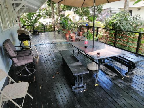 um deque com uma mesa, cadeiras e um guarda-sol em Casa Gamboa Remodelada em Gamboa