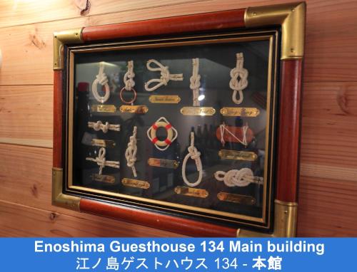 a frame display case of various types of belts and handcuffs at Enoshima Guest House 134 in Fujisawa