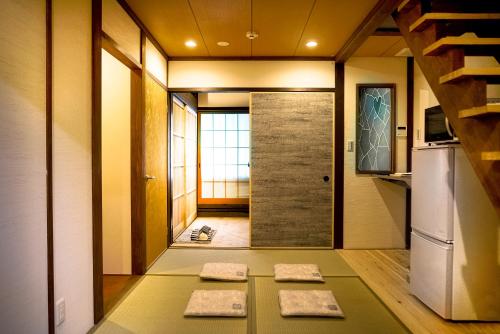 a hallway with a door and two mats on the floor at INN Plus Toji Fushin in Kyoto