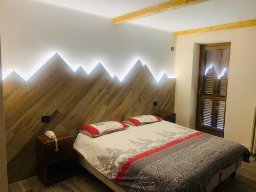 a bedroom with a bed with a wooden wall at Hotel Ristorante Ligure in Vinadio