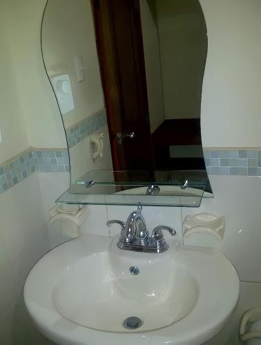 a bathroom sink with a mirror on top of it at Hotel Madrigal in Portoviejo