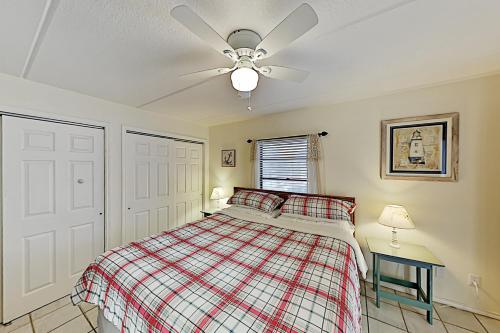 een slaapkamer met een bed en een plafondventilator bij Habitat Condos in South Padre Island