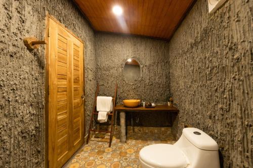 a bathroom with a toilet and a wooden door at Mafiya Resort in Koh Rong Island