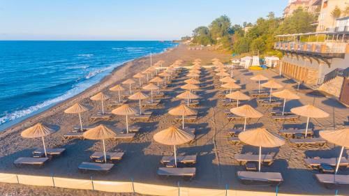 a group of chairs and umbrellas on a beach at Atik Hotel in Unye