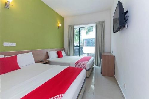 a hotel room with two beds and a flat screen tv at Bintang Garden Hotel in Kuala Lumpur