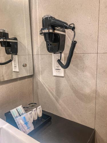 a phone is attached to a wall in a bathroom at BeSS Mansion Hotel Surabaya in Wonocolo