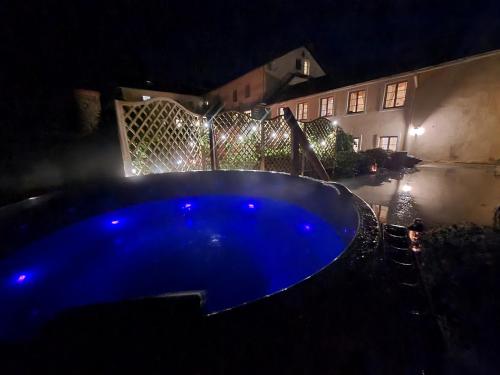 a blue swimming pool in a yard at night at Bille in Bille