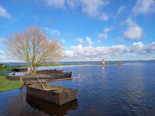 two boats sitting in the water on a lake at Lac Grand Lieu : maisonnette au calme avec jardin in Saint-Lumine-de-Coutais