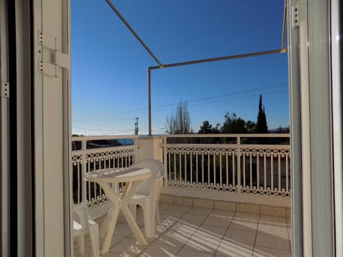 a balcony with a white chair and a table and a window at JERRY'S STUDIOS LASSI in Lassi
