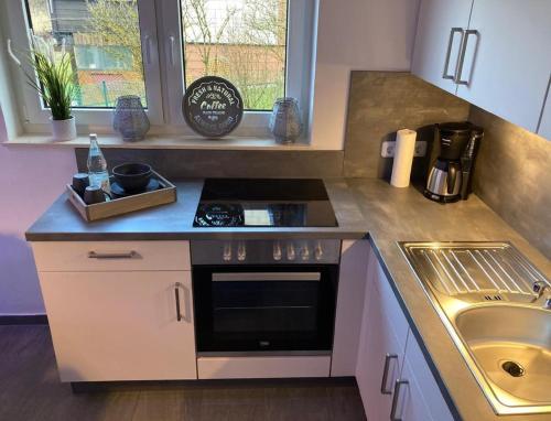 a small kitchen with a stove and a sink at Ferienwohnung Behnke in Brand