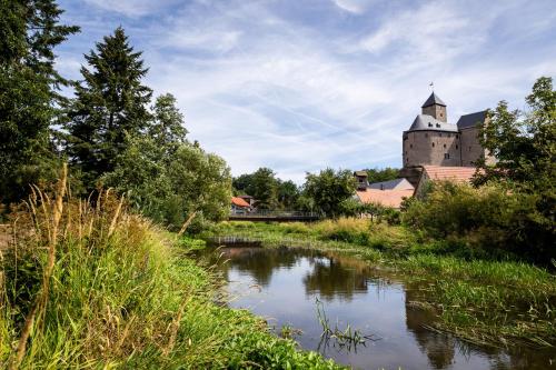 a castle and a river in front of a building at Ferienwohnung Behnke in Brand