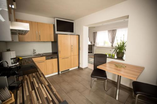 a kitchen with a table and a dining room at Pension Knoll in Schörfling