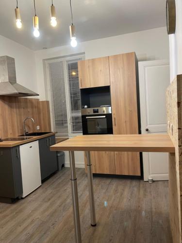 a kitchen with wooden cabinets and a wooden table at Logement entier: Appartement avec Terrasse Quartier de la Gare in Amboise