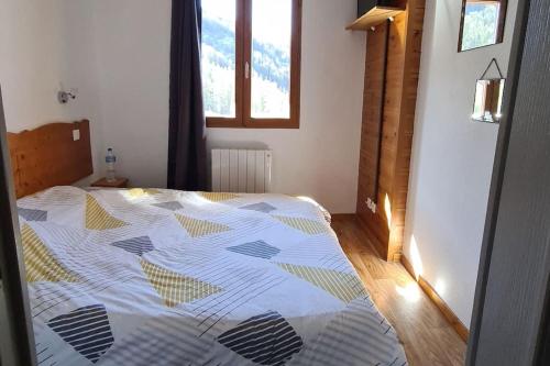 a bedroom with a bed with a comforter on it at T2 Cosy à 50m des pistes, 6 pers Puystvincent 1800 in Puy-Saint-Vincent