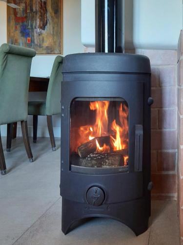 a stove with a fire in a living room at Apartamentos Rurales Entre Fuentes in Cuacos de Yuste