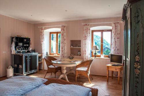 a bedroom with a bed and a table and a kitchen at Almbauernhof in Ruhpolding