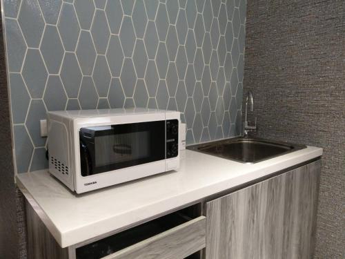 a microwave sitting on a counter next to a sink at HINOEN Hotel in Taipei