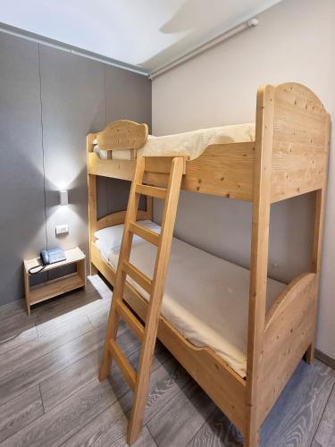 a room with two bunk beds and a lamp at Hotel Alla Fonte in Arta Terme
