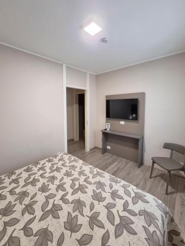 a bedroom with a bed and a flat screen tv at Hotel Alla Fonte in Arta Terme