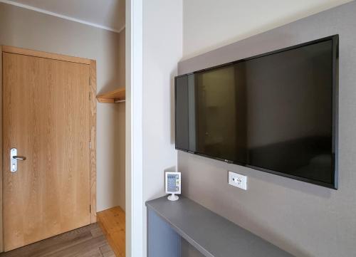 a large flat screen tv hanging on a wall at Hotel Alla Fonte in Arta Terme