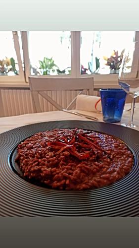 a pizza sitting on top of a plate on a table at Hotel Ristorante Parco Belvedere in Pescate