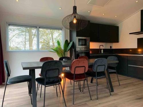 a kitchen with a dining room table and chairs at Nieuw! 6-persoons chalet aan het Veluwemeer dichtbij Harderwijk, Amersfoort en Zwolle in Hulshorst