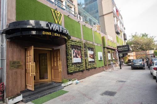 a green building with a sign on the side of a street at Golden Parkk Hotel in Kolkata