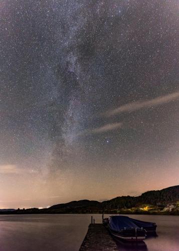 a boat on the water under a starry sky at Lochend Chalets in Port of Menteith