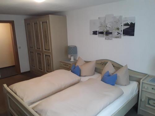 a bedroom with two beds with blue pillows at Pension Waldeck Fleckl in Warmensteinach
