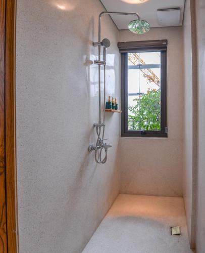 a shower in a bathroom with a window at 22Land Hotel & Residence in Hanoi