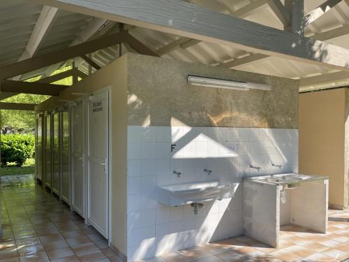 a bathroom with a sink and a mirror at Camping Le Jardin - chalets, bungalows et emplacements nus pour des vacances nature le long de la rivière le Gijou in Lacaze