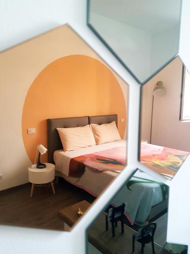 a bedroom with a bed with an orange wall at Sleep & Fly Malpensa in Case Nuove