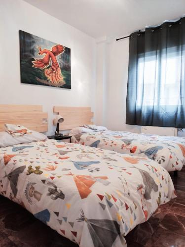 sypialnia z 2 łóżkami i obrazem na ścianie w obiekcie La casita del río 2 w Grenadzie