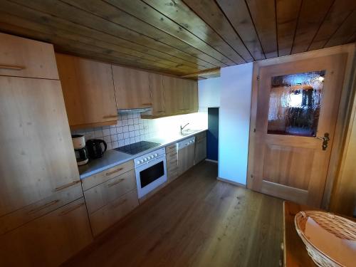 a kitchen with wooden cabinets and a stove top oven at Haus Schroefler in Lech am Arlberg