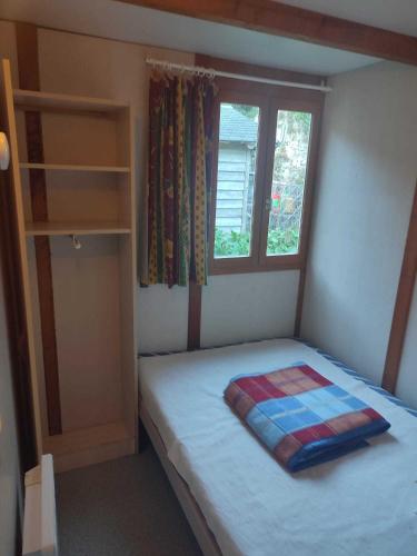 une petite chambre avec un lit et une fenêtre dans l'établissement Camping Le Jardin - chalets, bungalows et emplacements nus pour des vacances nature le long de la rivière le Gijou, à Lacaze