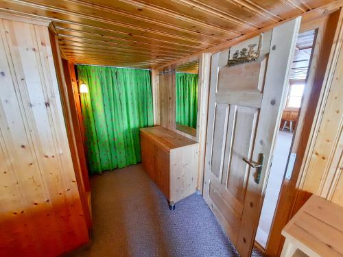a small room with green curtains and a door at Haus Schroefler in Lech am Arlberg