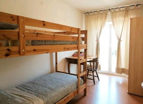 1 dormitorio con 2 literas y escritorio en Appartamenti Viola, en Cavedago
